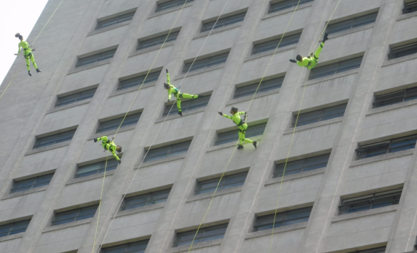 Shopping Leblon se prepara para o Rio Open com bailarinos suspensos na fachada para uma partida de tênis coreografada