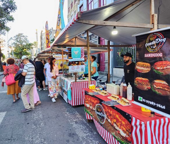 Neste mês de outubro, a Feira do Lavradio completa 30 anos de muitas histórias e conquistas na Rua do Lavradio, no Centro. Para festejar uma data tão especial, o Polo Novo Rio Antigo, grupo responsável pela realização da Feira, presenteia seu público com duas novidades, todo sábado do mês – um circuito inédito gastronômico com diversas delícias e o Samba da Feira, uma animada roda de samba capitaneada por grandes músicos. O Polo Gastronômico da Feira do Lavradio é o convite perfeito para se deliciar pelas culinárias de vários países, que traz aquela vibe democrática da melhor comida de rua carioca. E o melhor: com opções de pratos para todos os bolsos e gostos. No espaço, que tem início a partir das 11h, expositores que já conquistaram o coração de quem passa pela Feira do Lavradio, como Latifa, de gastronomia nigeriana; Sabor da Roça, de sanduíches com linguiça mineira artesanal; Cookie Pisca, com seus deliciosos e divertidos recheios; Brewteco, de cervejas artesanais; Carvão & Barbante, que tem entre suas especialidades o Torresmo de Rolo; Que Isso Pão de Alho, com várias opções de pães e recheios; D’Ju, de deliciosos doces e tortas; e Doceria Coutinho, com seus clássicos macarrons. E para fazer companhia a uma boa gastronomia nada melhor que muita música. Pensando nisso, a Feira do Lavradio promove todo sábado, às 14h, o Samba da Feira, uma animada roda de samba com músicos que sempre entregam o melhor do samba raiz. Antes disso, o som fica por conta do DJ. O evento é gratuito! É só chegar na Praça Lima Barreto, que fica em frente ao CIEP José Pedro Varela